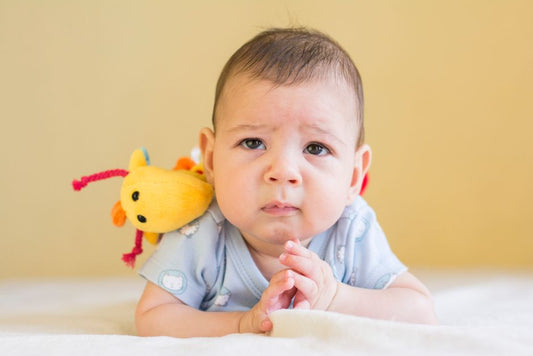 Bébé de 2 mois qui tient sa tête sur le ventre